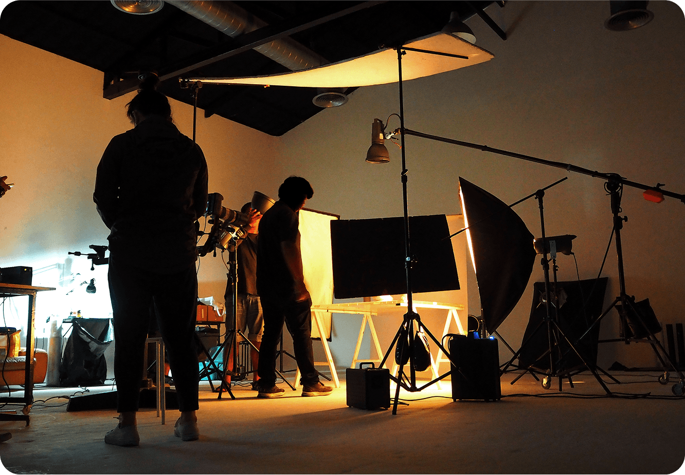 Film crew working in dimly lit studio.