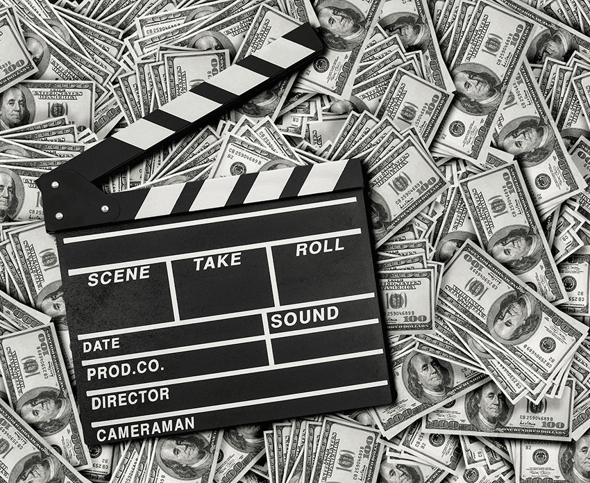 Clapperboard on scattered hundred dollar bills.