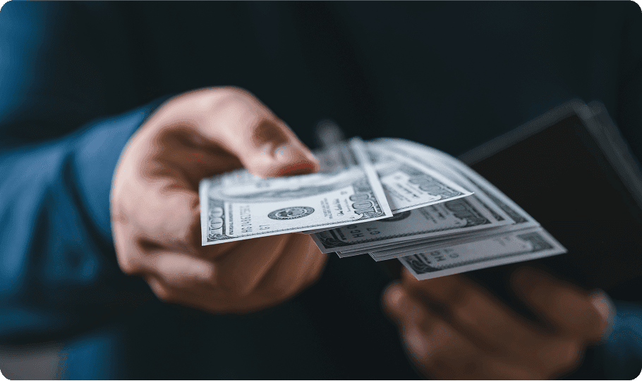 Hand holding US dollar bills and wallet.