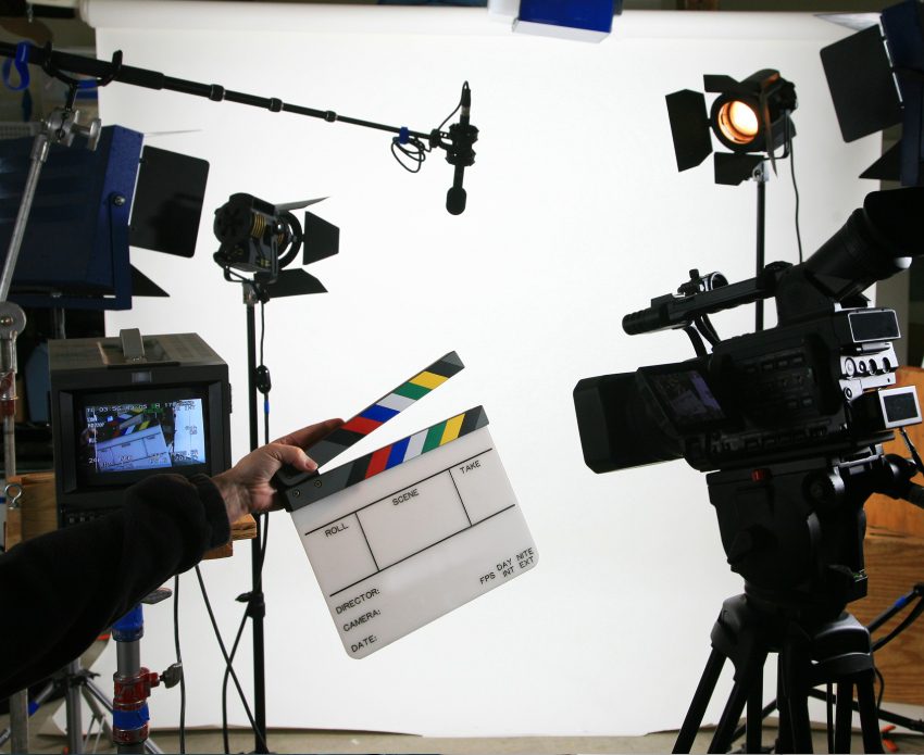Film set with clapperboard and camera setup.